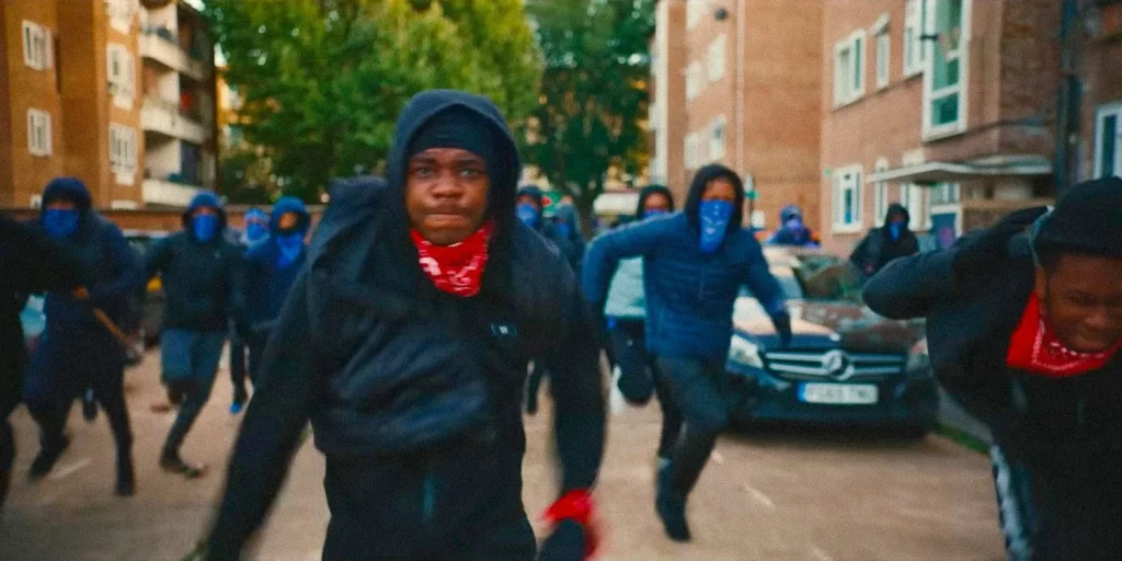 Gang members in hoodies and bandanas running through a South London estate in Supacell