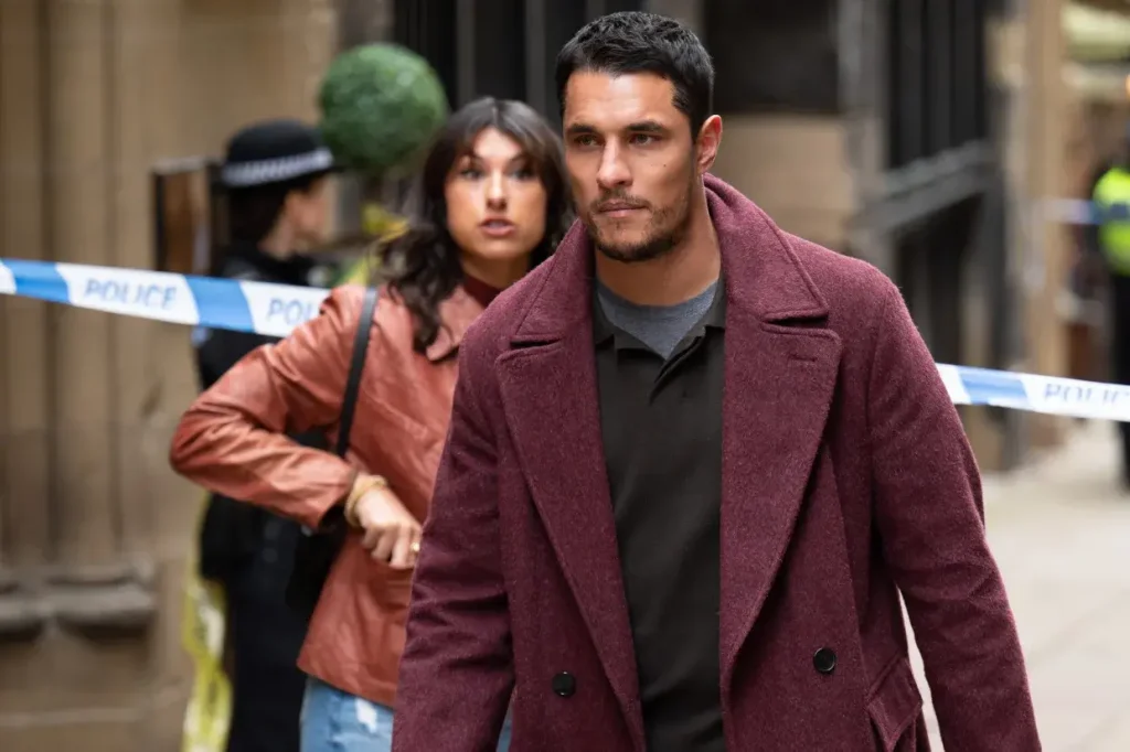 Detective Harry Virdee walking past a crime scene tape with Saima in the background in BBC’s 2025 drama Virdee.